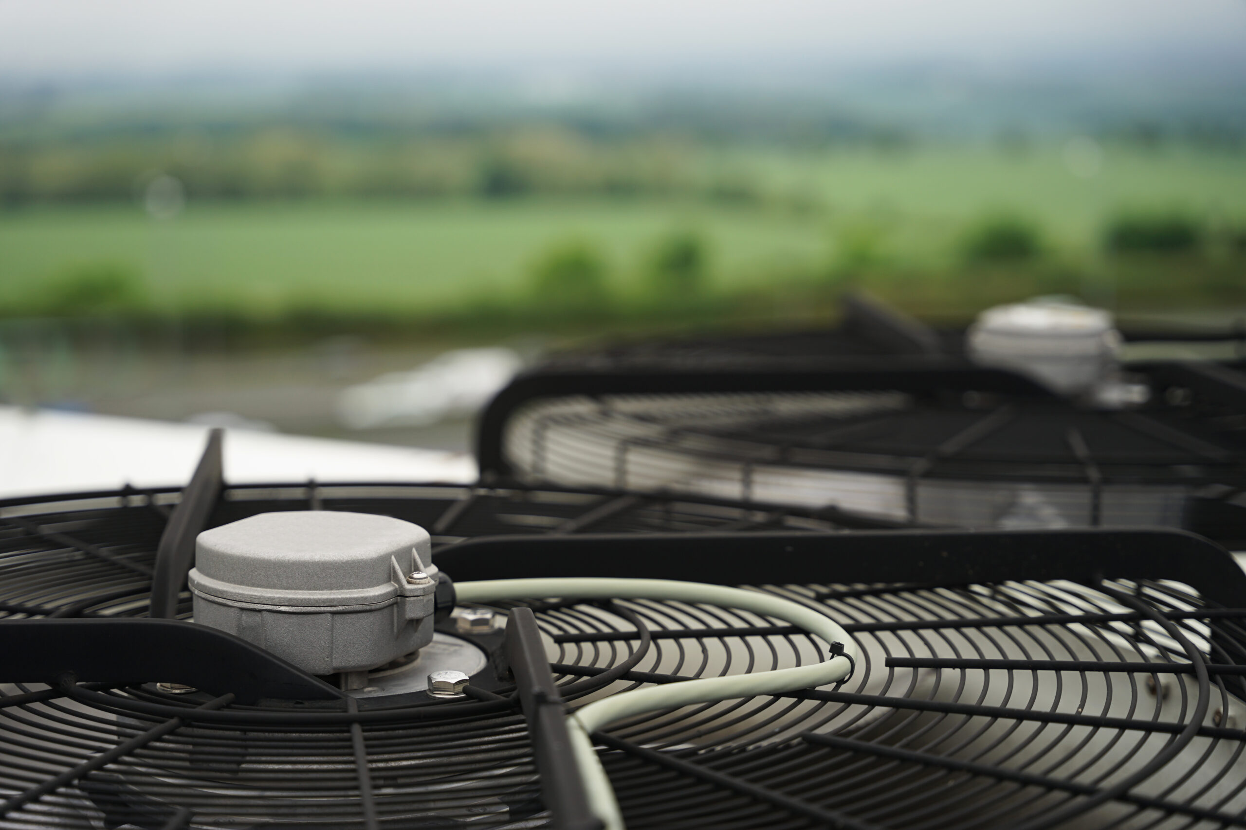 Close-up of industrial condenser fan on roof used in air conditioning, refrigeration, heat pump systems, green energy future concept